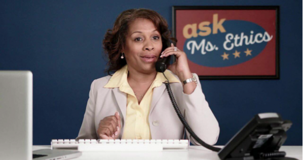 Photo of a woman on the phone in front of an Ask Ms. Ethics poster